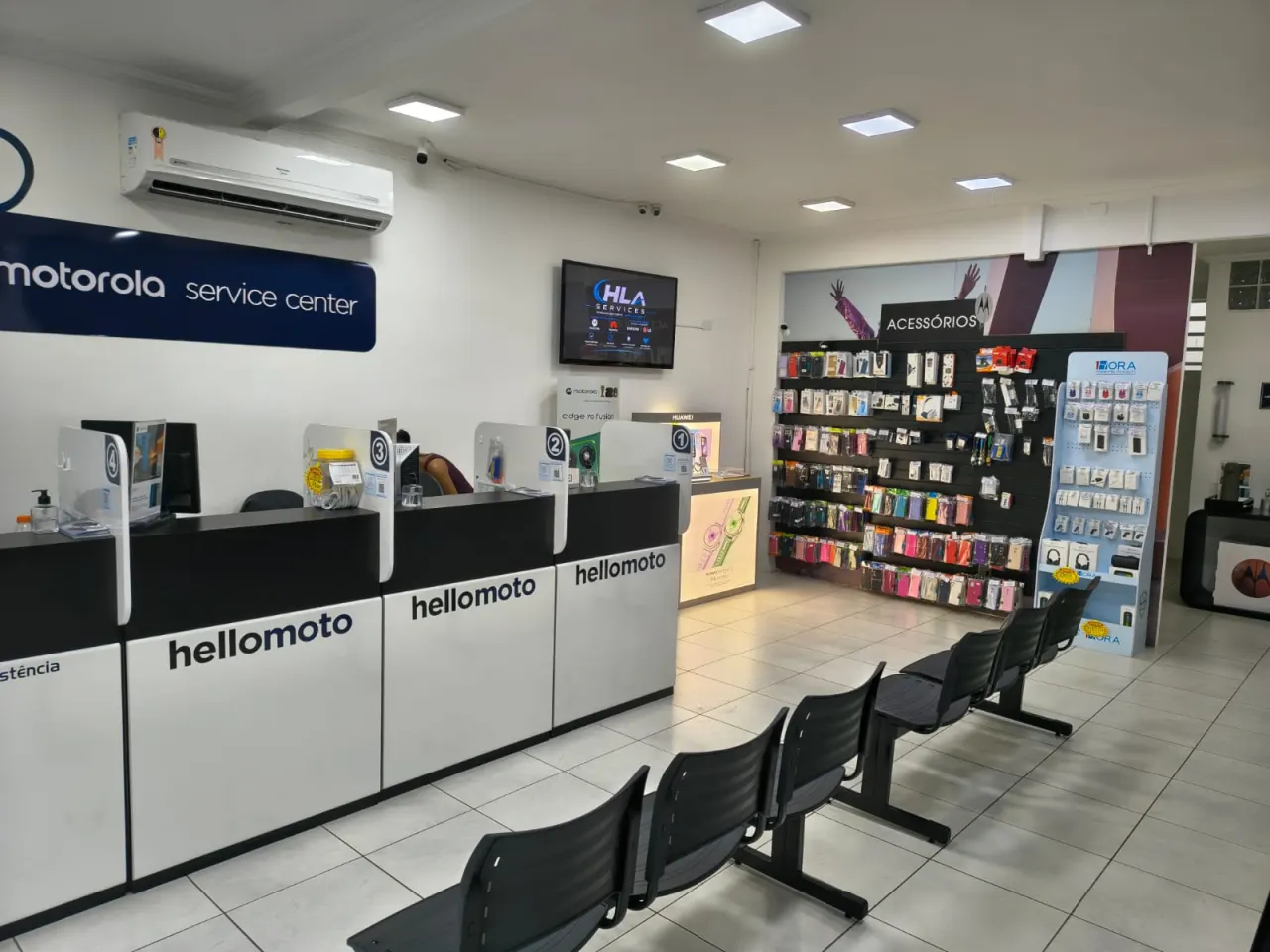 Recepção da HLA Services com balcões Motorola Service Center e parede de acessórios
